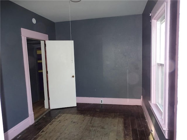 empty room featuring baseboards and hardwood / wood-style floors