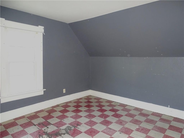 bonus room featuring lofted ceiling, baseboards, and tile patterned floors