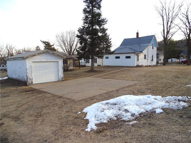 view of yard featuring a detached garage, an outbuilding, and driveway