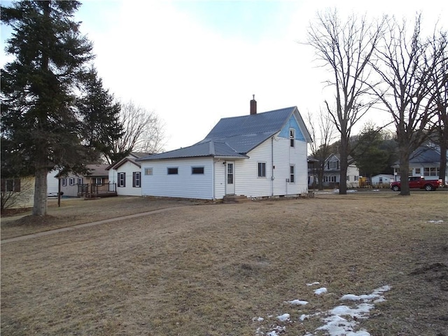 exterior space with a chimney and metal roof