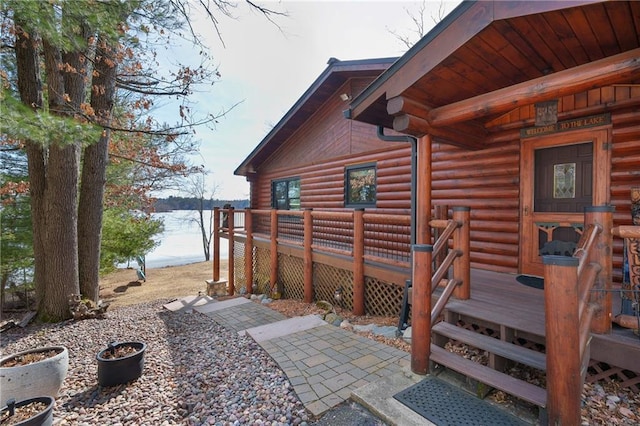 exterior space featuring a wooden deck, log exterior, and entry steps