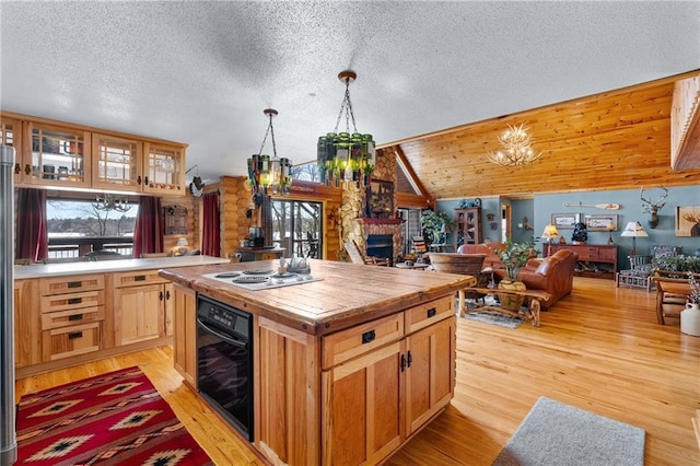 kitchen with light wood finished floors, oven, butcher block countertops, open floor plan, and vaulted ceiling