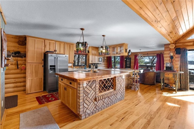 kitchen featuring a kitchen island, high end fridge, a textured ceiling, wood counters, and light wood-type flooring