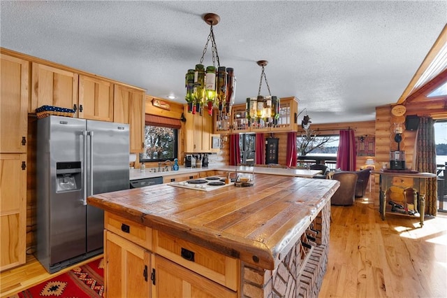 kitchen featuring a wealth of natural light, light wood-style floors, white electric cooktop, and stainless steel refrigerator with ice dispenser