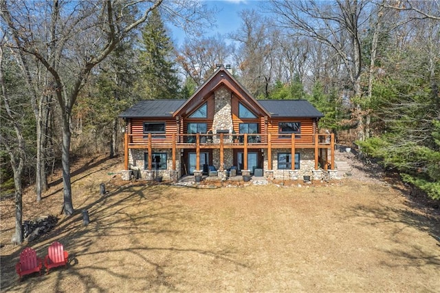 rear view of property featuring a wooden deck, stone siding, and log exterior