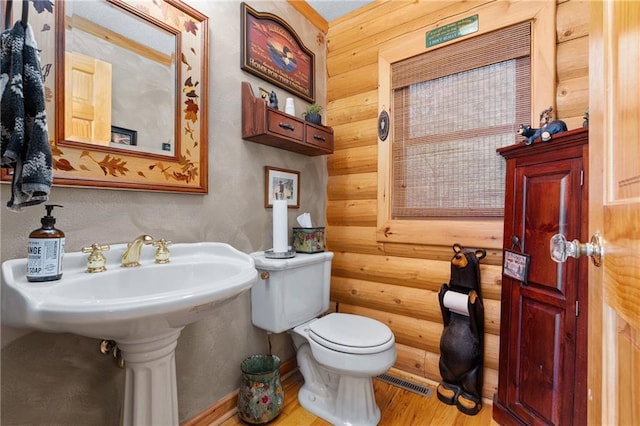 half bath with toilet and wood finished floors