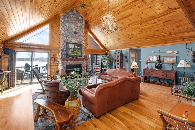 living room with rustic walls, wood finished floors, a chandelier, and a fireplace