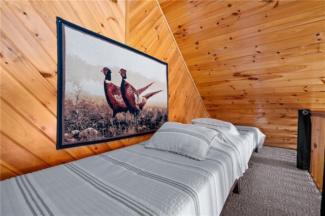 bedroom with wooden walls and carpet flooring