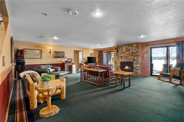 carpeted living room featuring a fireplace and a textured ceiling