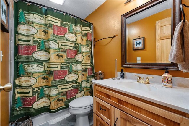 bathroom with a shower with shower curtain, toilet, vanity, and tile patterned flooring