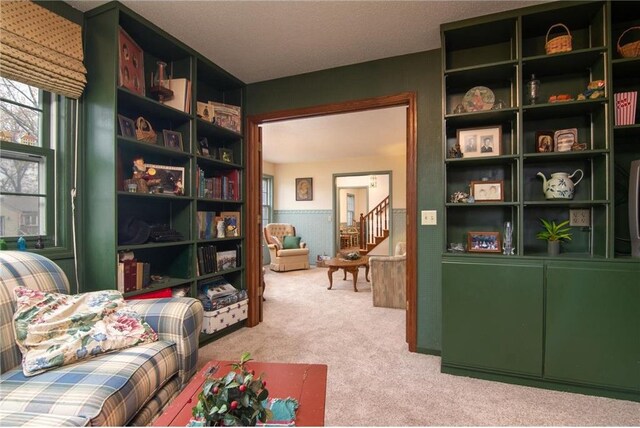 227 Donatelle St, Amery, WI 54001 - sitting room featuring a wainscoted wall, light colored carpet, and stairway