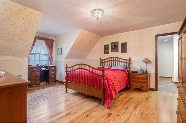 227 Donatelle St, Amery, WI 54001 - bedroom featuring light wood-type flooring, baseboards, a textured ceiling, and wallpapered walls