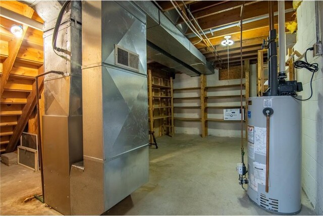 227 Donatelle St, Amery, WI 54001 - unfinished below grade area with heating unit, gas water heater, and concrete block wall