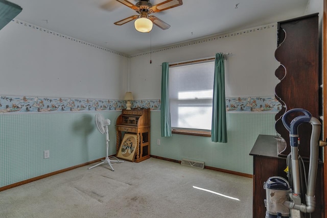 spare room with wallpapered walls, a wainscoted wall, visible vents, and carpet floors