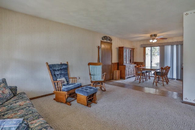 carpeted living area featuring baseboards and ceiling fan