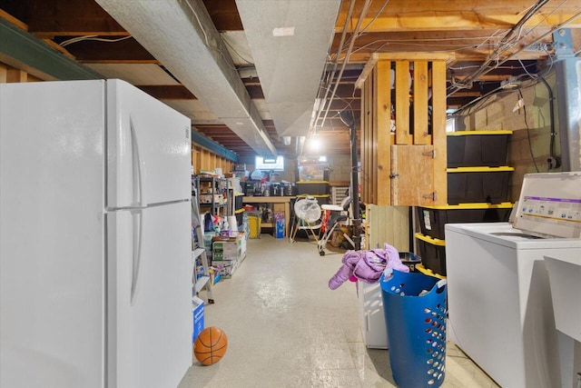 basement with washer / clothes dryer and freestanding refrigerator