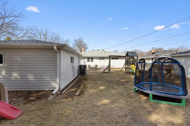 view of yard featuring a playground and a trampoline