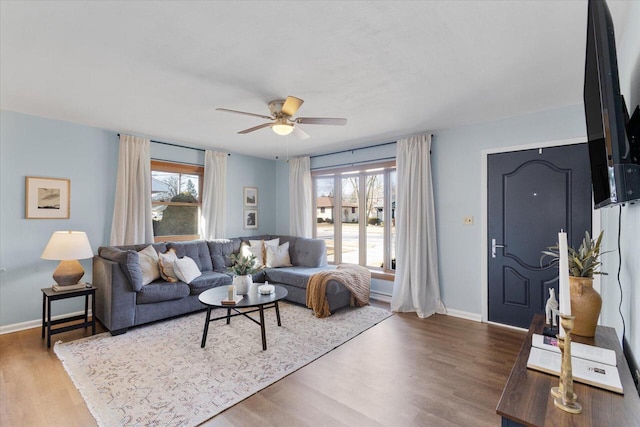 living room with a ceiling fan, wood finished floors, and baseboards