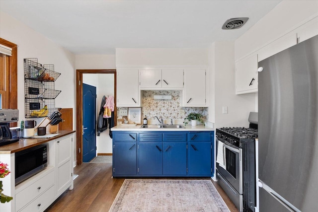 kitchen with decorative backsplash, blue cabinetry, stainless steel appliances, and a sink