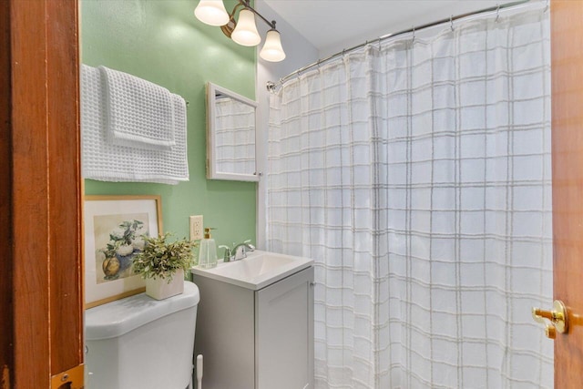 full bath with a shower with curtain, toilet, and vanity