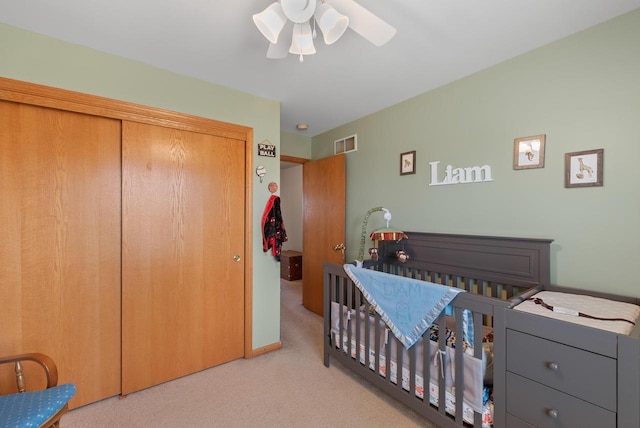 bedroom with a ceiling fan, visible vents, baseboards, a closet, and carpet flooring