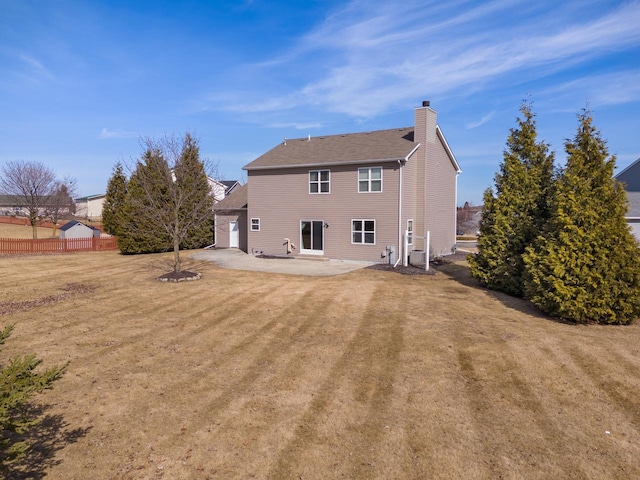 back of house with fence, a lawn, a chimney, a patio area, and driveway