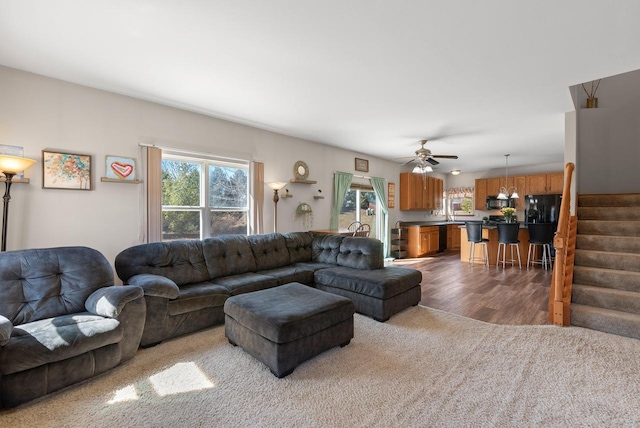 living room with wood finished floors, stairway, and a ceiling fan