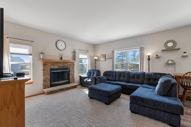 living area with baseboards and a stone fireplace