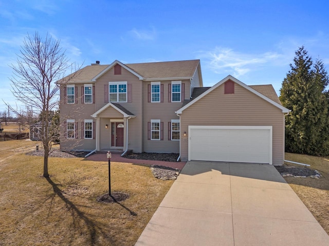 colonial home with an attached garage, concrete driveway, and a front lawn