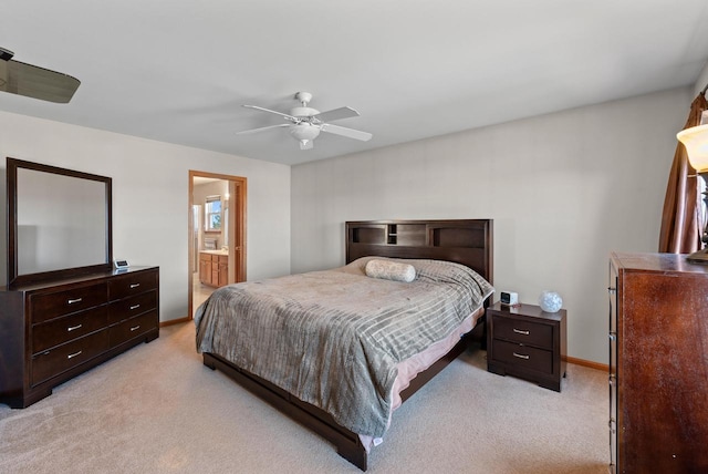 bedroom with a ceiling fan, light colored carpet, baseboards, and ensuite bathroom