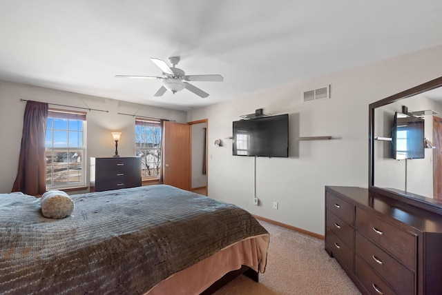 bedroom with light carpet, visible vents, a ceiling fan, and baseboards