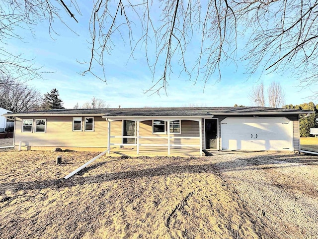 view of front facade with an attached garage and gravel driveway