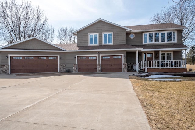 craftsman-style home with a porch, roof with shingles, a garage, stone siding, and driveway