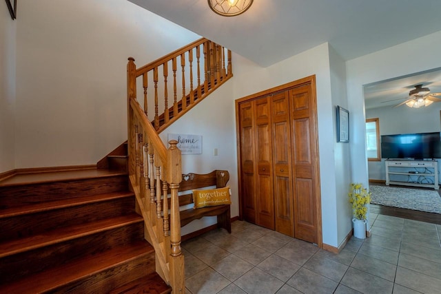 stairway featuring tile patterned floors, baseboards, and ceiling fan