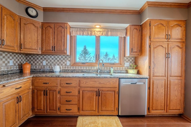 kitchen with light stone countertops, dark wood finished floors, a sink, dishwasher, and crown molding