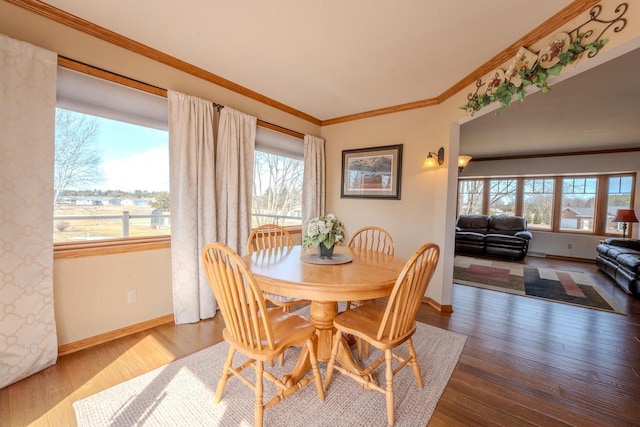 dining room featuring wood finished floors, baseboards, and ornamental molding