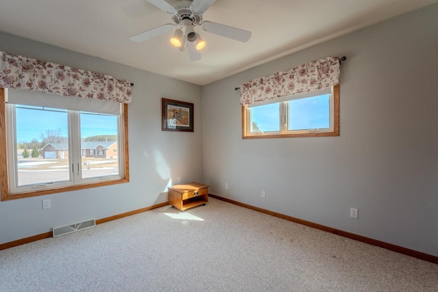 unfurnished room with baseboards, visible vents, carpet floors, and ceiling fan