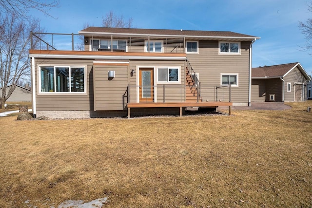 rear view of property featuring a lawn and a balcony