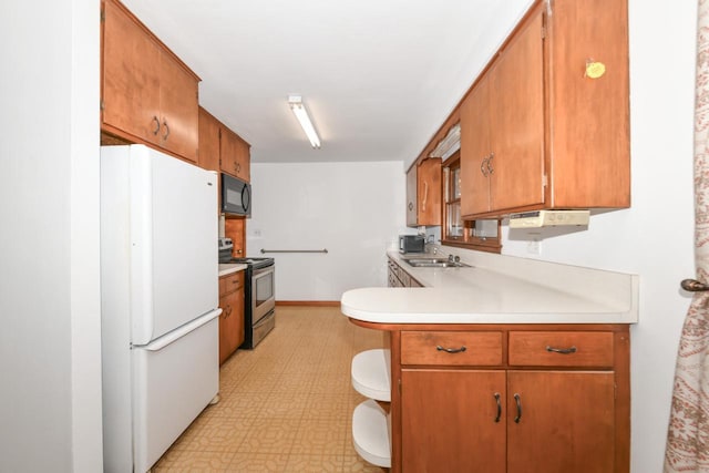 kitchen with freestanding refrigerator, a sink, light countertops, stainless steel range with electric stovetop, and black microwave