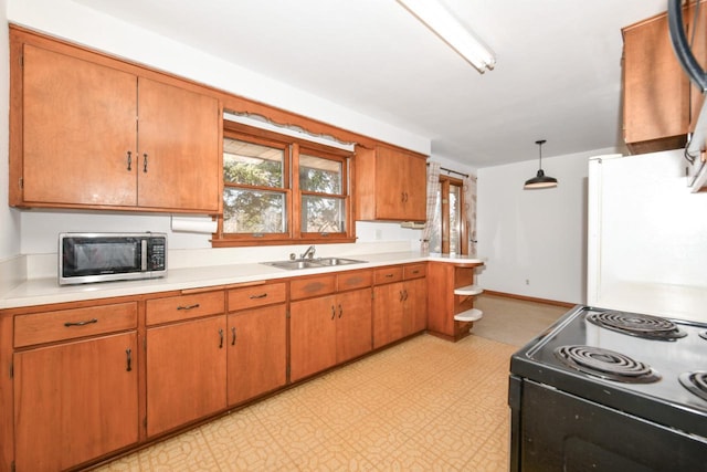 kitchen with stainless steel microwave, light floors, black range with electric stovetop, and a sink