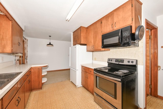 kitchen featuring light floors, freestanding refrigerator, stainless steel range with electric stovetop, black microwave, and brown cabinets