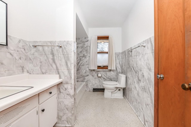 full bathroom with vanity, tile walls, toilet, and a bathtub