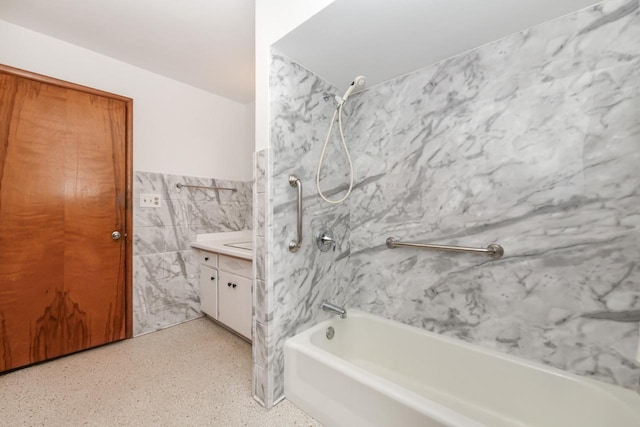 bathroom with vanity, tile walls, and shower / washtub combination