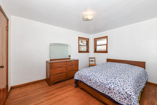 bedroom with baseboards and wood finished floors