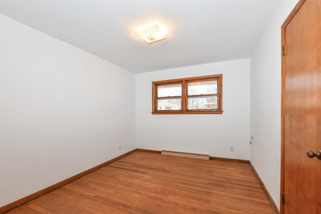 unfurnished room featuring light wood finished floors, baseboards, and baseboard heating