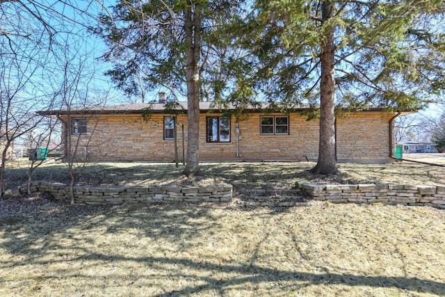 view of home's exterior featuring stone siding and a chimney