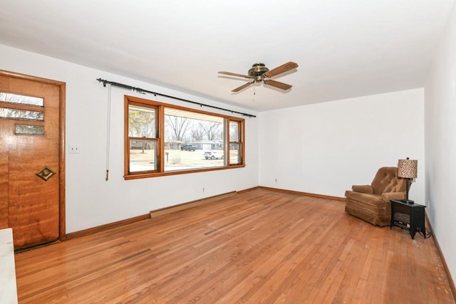 unfurnished room featuring light wood-type flooring, baseboards, baseboard heating, and ceiling fan