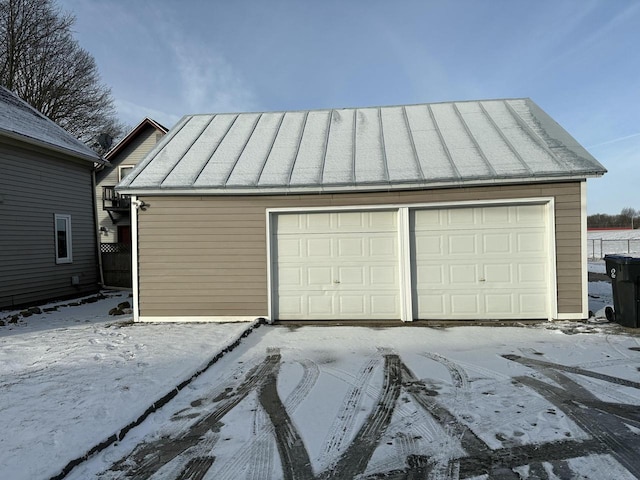 snow covered garage featuring a garage