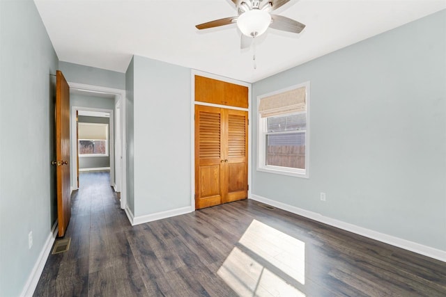 unfurnished bedroom with visible vents, baseboards, ceiling fan, dark wood finished floors, and a closet