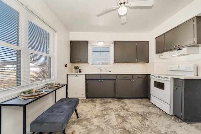 kitchen with ceiling fan, under cabinet range hood, decorative backsplash, white appliances, and a sink